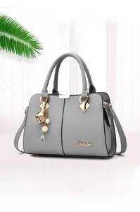 Close-up of grey litchi texture leather tote with elegant pearl flower charm