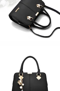 Detail of black lychee grain leather handbag with gold hardware and flower charm