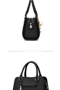 Detail of black litchi texture handbag with gold zipper and pearl floral charm