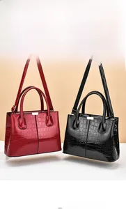 Detailed comparison of red and black crocodile embossed patent leather tote bags with gold hardware