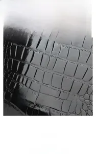 Detail of midnight black cowhide leather featuring glossy crocodile embossed texture