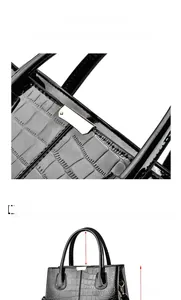 Detail of glossy black crocodile embossed handbag showing gold hardware and dimensions