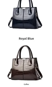Detail of glossy crocodile embossed patent leather handbags in royal blue and coffee colors