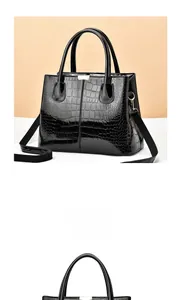 Detail of black crocodile texture tote bag with golden metal hardware and strap