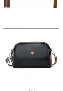 Close-up of black lychee grain leather mini bag with brown trim and silver hardware
