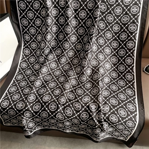 Close-up of luxury black and white silk shawl with retro cross patterns and satin texture