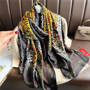 Detail of luxury leopard print long scarf draped over an armchair for styling