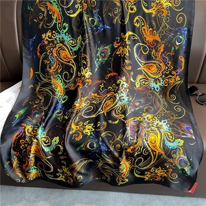 Detail of luxury long silk shawl with colorful paisley and peacock feather patterns