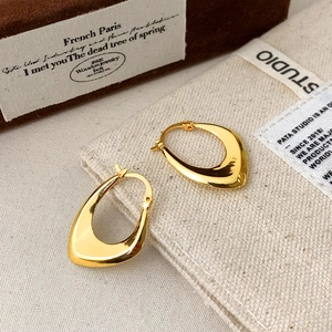 Close-up of 18K gold-plated teardrop hoop earrings with high-polished metal finish