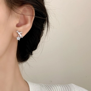 Sparkling zircon star pendant earrings on model showing elegant bow design