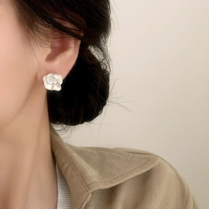 French style white rose flower stud earrings with gold trim worn by a model