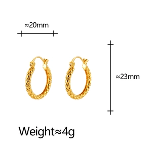 Minimalist gold U-shaped geometric earrings with classic quilted texture on white background