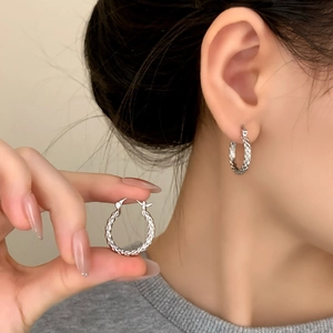 Minimalist silver geometric hoop earrings with intricate woven texture for a luxury style