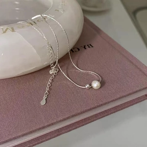 Elegant minimalist freshwater pearl necklace with silver chain on soft background