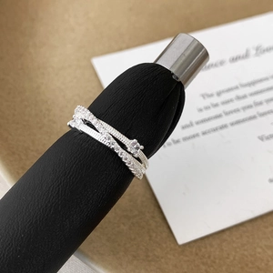 Macro shot of double-layered crisscross ring with zircons on a black velvet display stand
