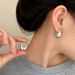 Orecchini a cerchio a goccia in argento lucido con design metallico minimalista a U