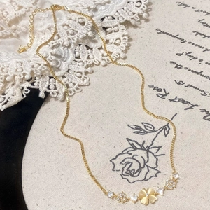 Elegant gold flower necklace with opal and zircon accents on vintage artistic background