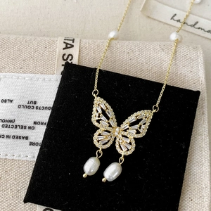 Elegant gold butterfly necklace featuring shimmering zircons and hanging freshwater pearls