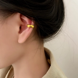 Elegant gold cuff earring with vertical texture shown on model for daily wear
