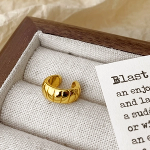 Golden croissant twist ear cuff with polished spiral texture in a premium wooden gift box