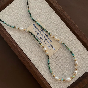 Baroque pearl necklace with turquoise beads and amethyst accents on jewelry box