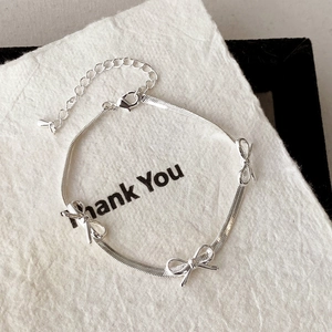Silver snake chain bracelet with elegant bow charms and adjustable lobster clasp
