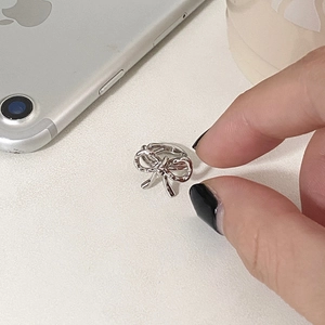 Dettaglio di un ear cuff a fiocco argento con finitura lucida a specchio