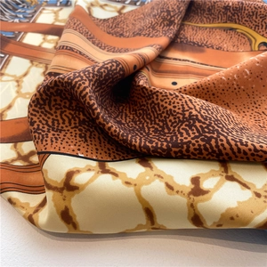 Macro detail of silk-like twill scarf showing orange and brown animal print texture