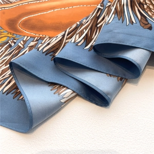 Detailed view of luxury silk scarf with feather print and premium hand-stitched edges