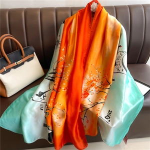 Detail of luxurious orange and teal silk scarf with hand-painted floral art texture