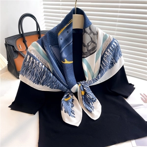 Elegant silk scarf with navy and yellow prints draped over a black shirt