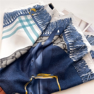 Detailed macro view of twill silk scarf showing vintage equestrian patterns and blue prints