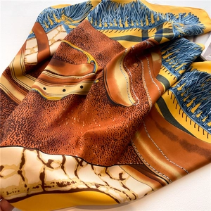 Macro detail of luxury equestrian print silk scarf with satin finish and golden tassels