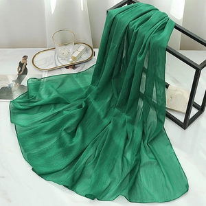 Detail of emerald green chiffon shawl with vertical pleats and metallic silver shimmer thread