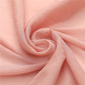 Close-up of pink textured chiffon fabric with subtle glitter silk and pleated details