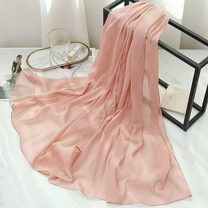 Detailed view of pale pink chiffon scarf texture with fine pleated folds and silky sheen