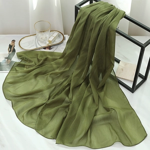 Detailed texture of olive green chiffon scarf with subtle metallic glitter threads