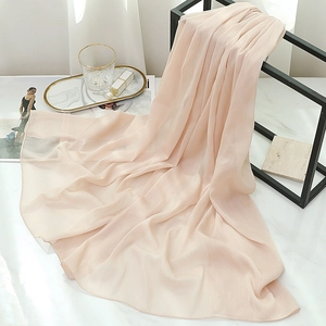Close-up of pleated soft pink chiffon scarf draped on a black metal display stand