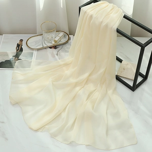 Detail of cream-colored chiffon scarf with pearlescent texture on a display stand