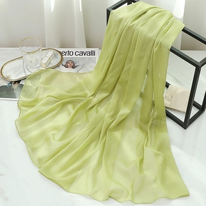Detail of light green chiffon scarf with subtle shimmer hanging in a stylish setting