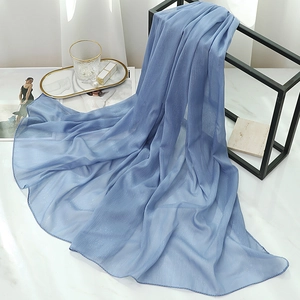 Detailed texture of light blue shimmer scarf with fine glitter on a display rack
