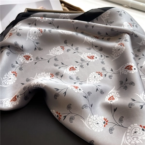 Detailed view of silky grey paisley scarf with black border and elegant heart patterns