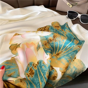 Détail d'un foulard en soie avec imprimé lotus et drapé souple avec accessoires élégants