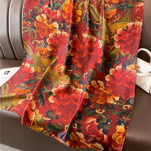 Détail d'une écharpe en soie de luxe avec imprimé phénix rouge et pivoine sur cuir