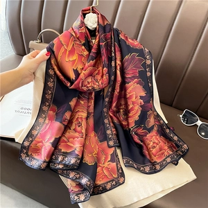 Détail d'un foulard en soie de luxe avec base violette et motif floral de pivoines oranges