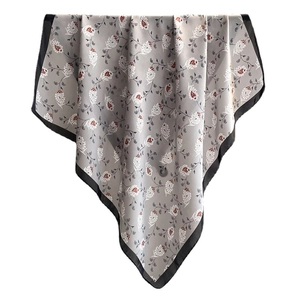 Silk-textured square scarf with red paisley print and black borders on light grey base