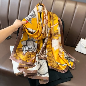 Détail d'un foulard en soie avec imprimé architectural classique et motifs floraux raffinés