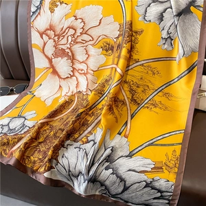 Écharpe élégante en soie jaune avec motifs floraux et bâtiments sur cuir brun