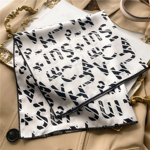 Detail of satin square scarf with Superman lettering on beige trench coat display