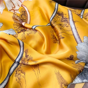 Vue macro détaillée de l'écharpe en soie jaune avec des motifs de paysages traditionnels